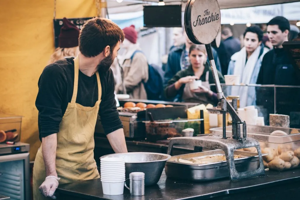 Una persona en un puesto de comidas - Fuente: Pexels