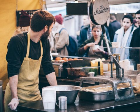 Una persona en un puesto de comidas - Fuente: Pexels