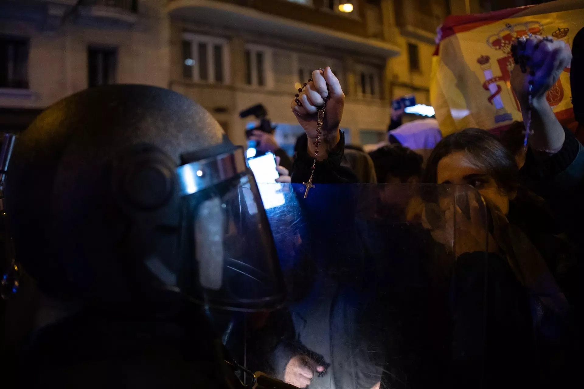 Manifestantes con rosarios en las manos se enfrentan a un agente de Policía, durante una protesta contra la amnistía frente a la sede del PSOE. — Alejandro Martínez Vélez / Europa Press