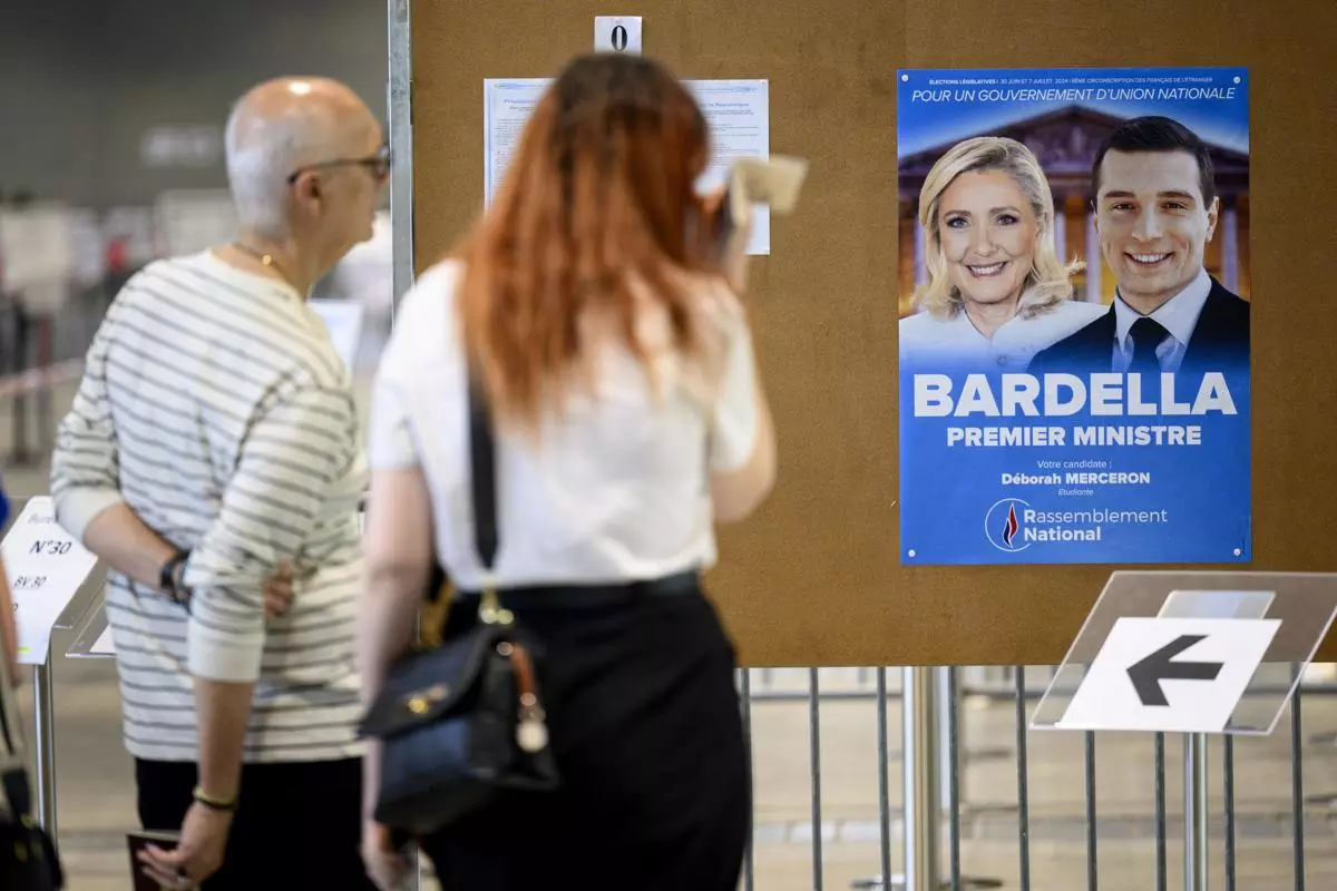 Cartel deL RN con la imagen de Marine Le Pen y Jordan Bardella en un colegio electoral de Lausana (Suiza). — Laurent Gillieron