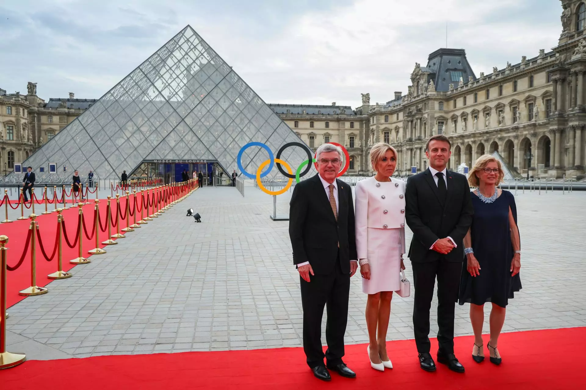 El presidente del Comité Olímpico Internacional (COI), Thomas Bach (i), y su esposa Claudia Bach (d), posan con el presidente francés, Emmanuel Macron, y su esposa, Brigitte Macron, a su llegada a la pirámide del Louvre. — EPA/LUDOVIC MARIN / Efe