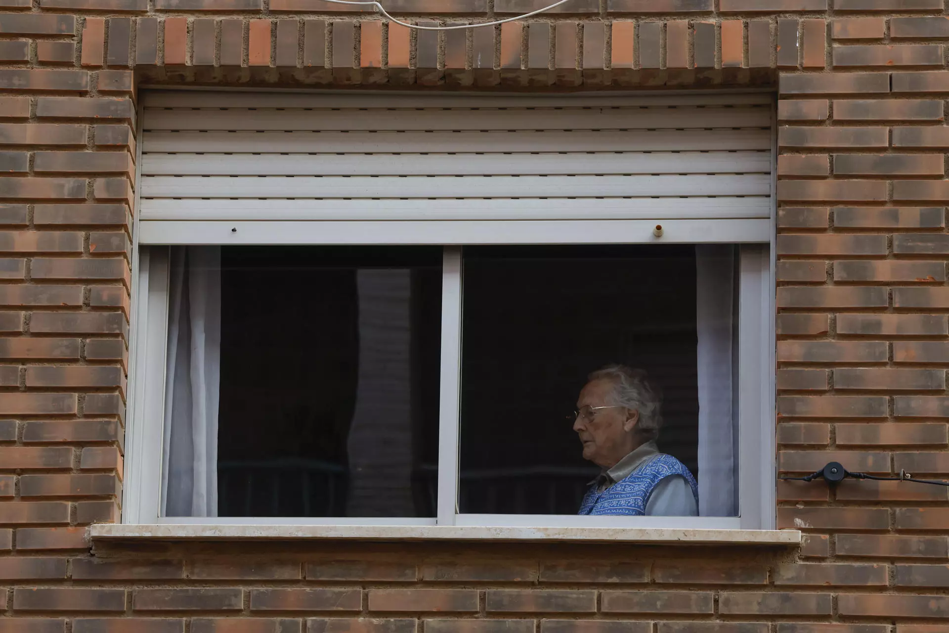 Una persona observa desde su casa las labores de limpieza en una calle en Catarroja, València, a 7 de noviembre de 2024. — J.J. Guillén / Efe