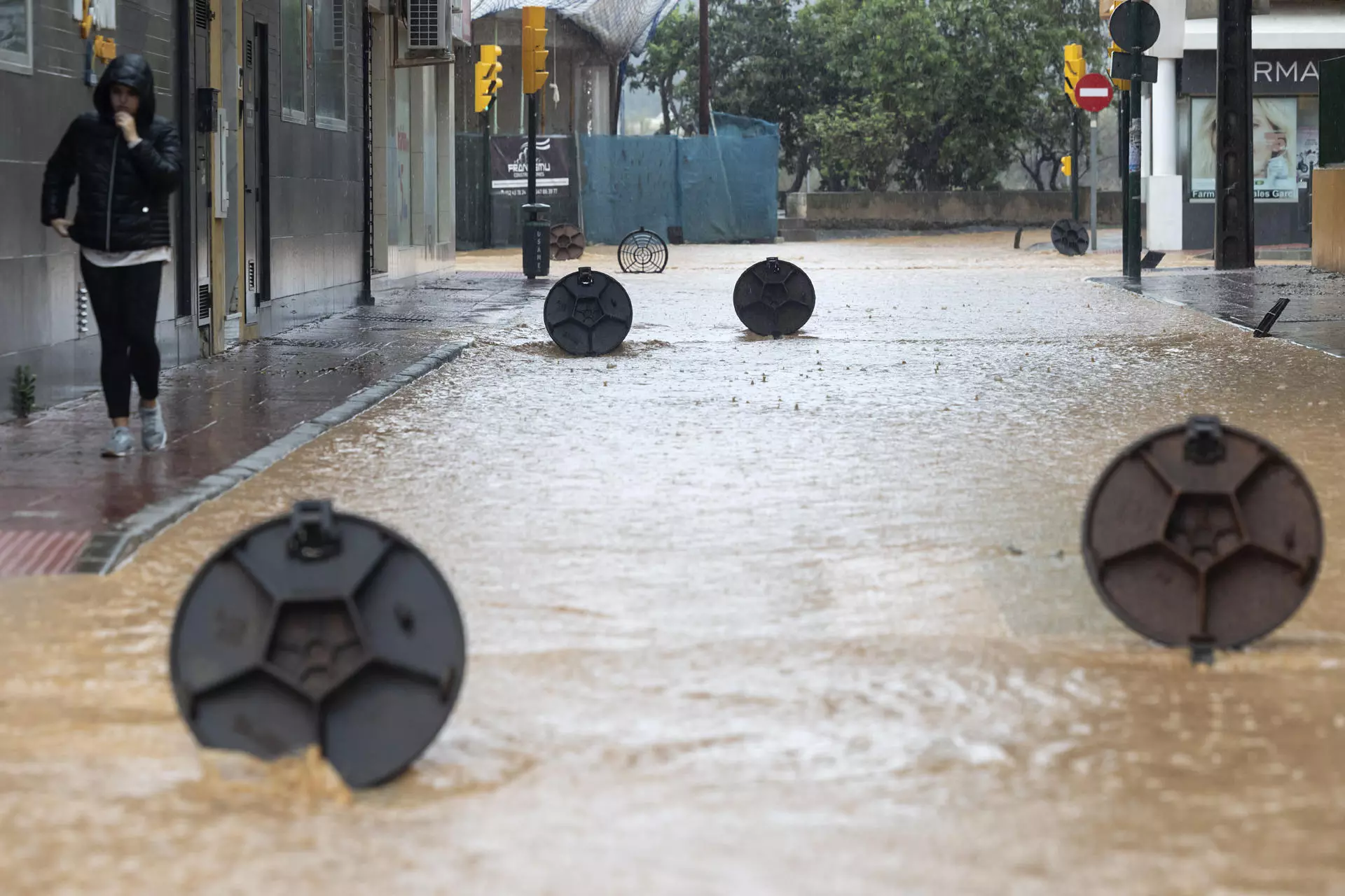 Cantarillas abiertas en una calle de la barriada de Campanillas en Málaga. — Daniel Pérez / EFE